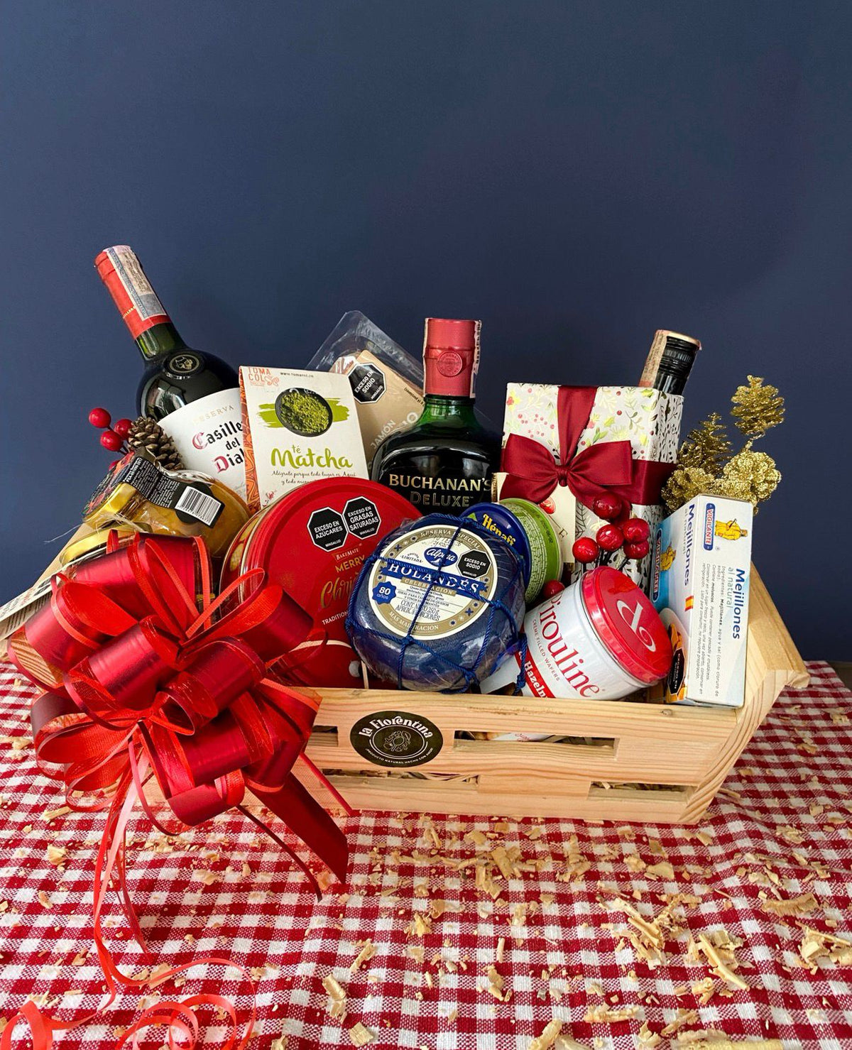 Trineo Premium Christmas: canasta trineo de madera con whisky Buchanan's, vino Gato Negro, crema de whisky Baileys, jamón serrano y chocolates Delafaille